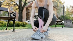 Woman in Active Wear Tying her Shoe Lace