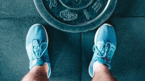 Black Steel Gym Plate and Pair of Blue Running Shoes