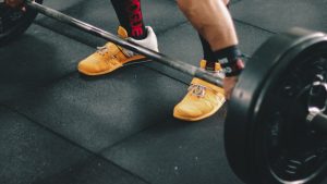 Person About to Start Lifting the Barbell Inside the Gym