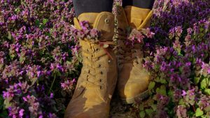 Person Wearing Brown Leather Boots Standing on Purple Flower Field