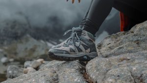 Person Wearing Hiking Shoes Sitting on a Rock
