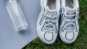 White and Blue Running Shoes on Gray Yoga Mat