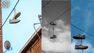 Brown Shoes Hanging on Black Cable Wire Under Blue Sky