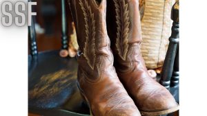 Photo of a Pair of Cowboy Shoes Standing on a Wooden Chair