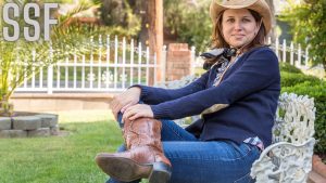 Photo of a Woman in a Blue Sweater Wearing Cowboy Boots