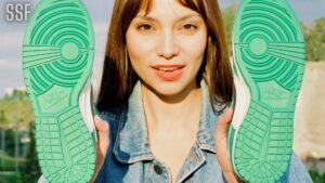 Woman in Blue Denim Jacket Holding Green and White Shoes