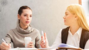 Two Women Holding Pen